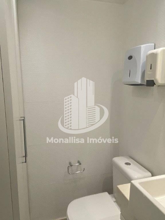 Lavabo da sala comercial no Le Monde Office visto de outro ângulo, com dispensers e vaso sanitário