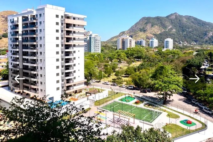 Vista aérea do condomínio do apartamento em Copacabana, Posto 4, com torre branca, quadras poliesportivas e áreas de lazer