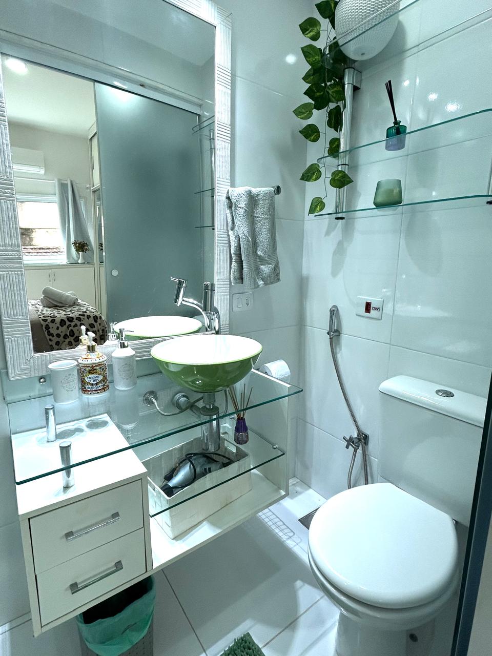 Banheiro da suíte do apartamento em Ipanema, com cuba verde sobre bancada de vidro
